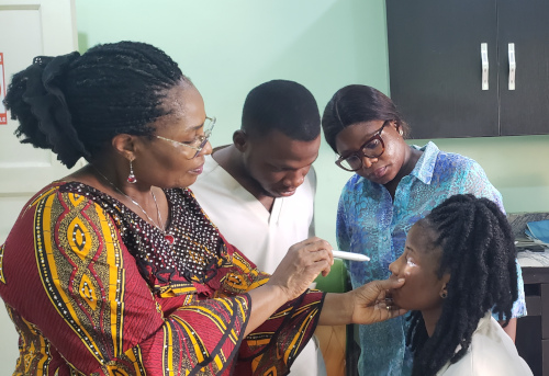 Charis Vision and Health Mission A woman examining a patient's eyes during optometry student training.