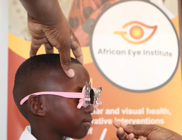 African Eye Institute - Child Eye Exam A photo of the side view of the head of a young child being given an eye exam through an Optometry Giving Sight funded program